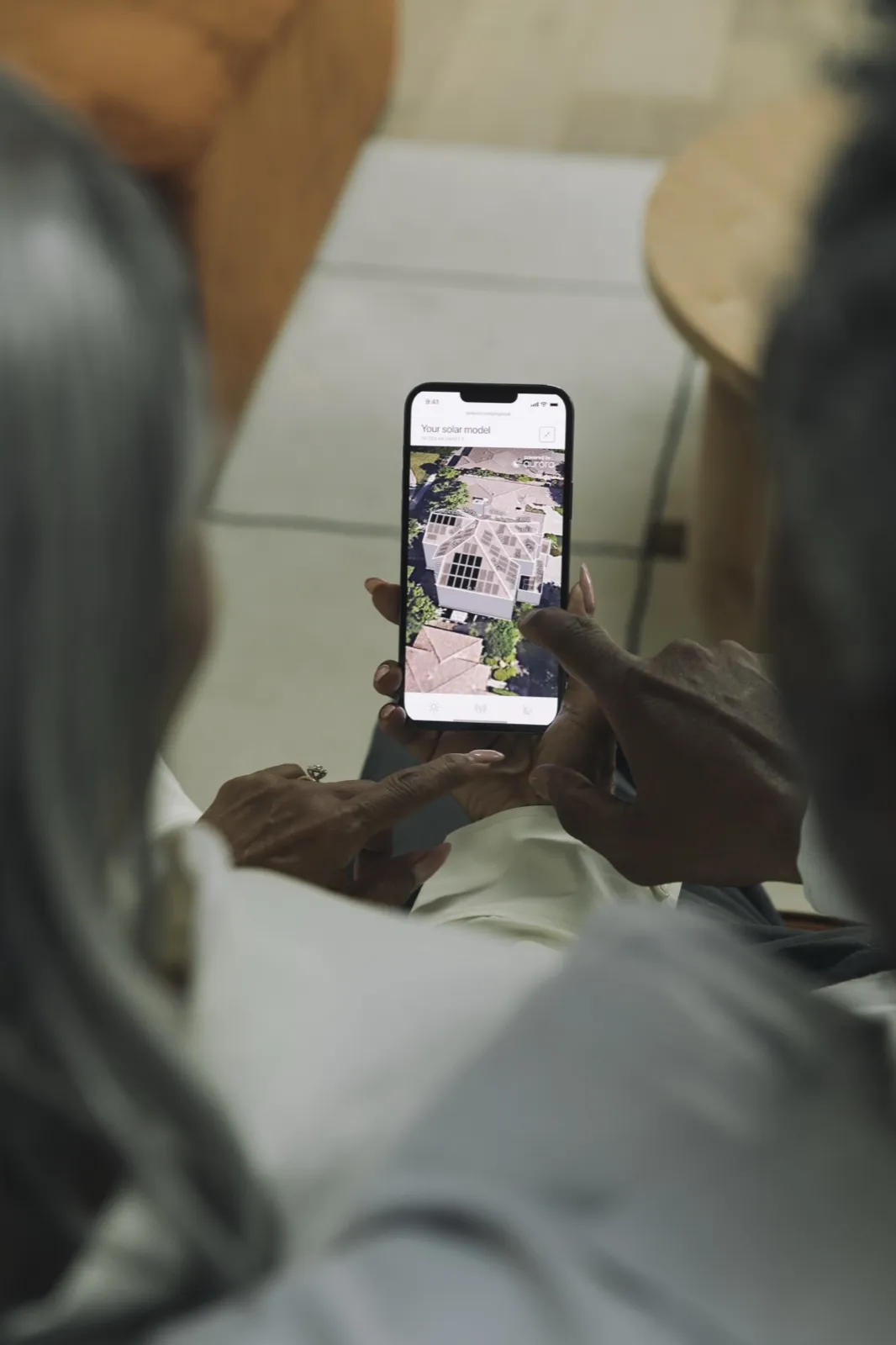 Two people reviewing a 3D solar model of their home on a phone